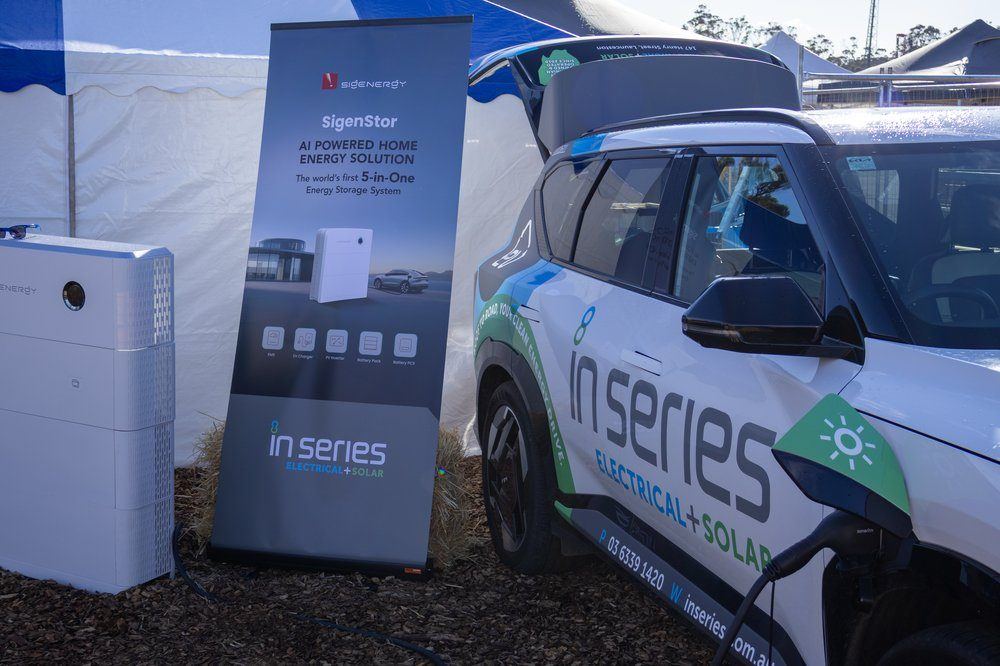 Sigenergy SigenStor display alongside an In Series branded electric vehicle at a trade event